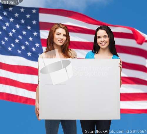 Image of two smiling young girls with blank white board