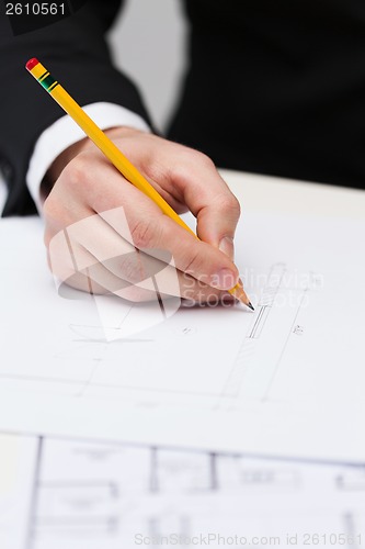 Image of male contractor making changes to blueprint