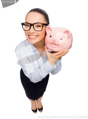 Image of happy businesswoman in eyeglasses with piggy bank