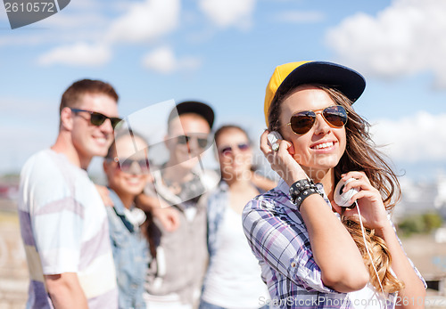 Image of teenage girl with headphones and friends outside