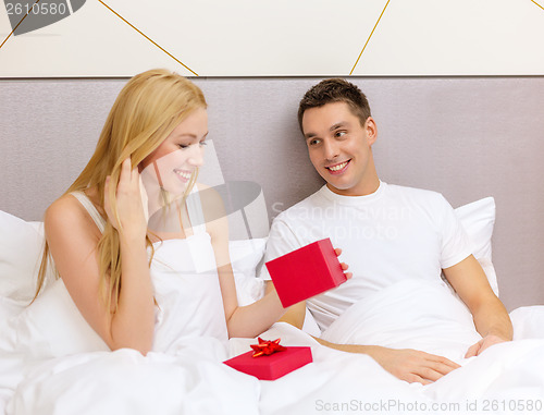 Image of man giving woman little red gift box