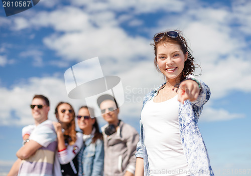 Image of teenage girl with headphones and friends outside