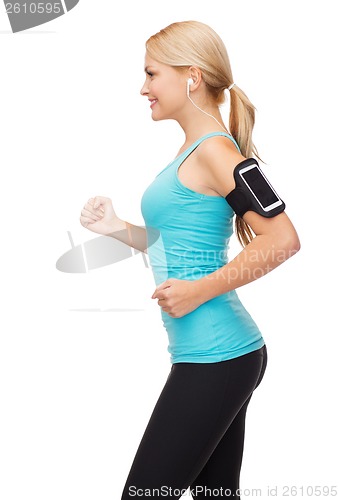 Image of sporty woman running with smartphone and earphones