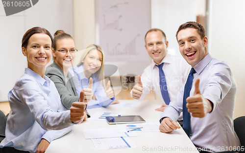 Image of business team showing thumbs up in office