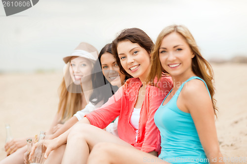 Image of smiling girls with drinks on the beach