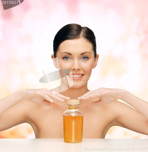 Image of beautiful woman with oil bottle