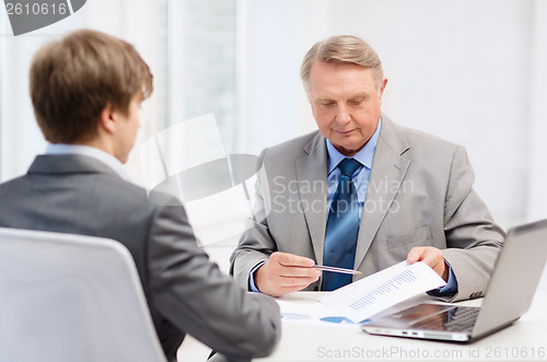 Image of older man and young man having meeting in office