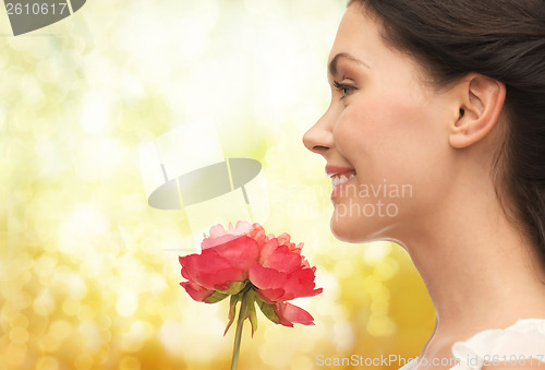 Image of smiling woman smelling flower
