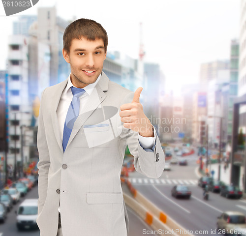 Image of smiling businessman showing thumbs up