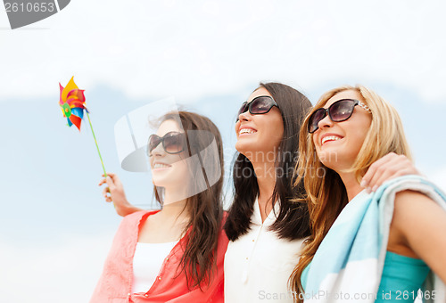 Image of smiling girls in shades having fun on the beach