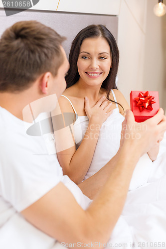 Image of man giving woman little red gift box