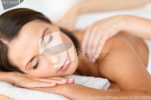 Image of beautiful woman in spa salon getting massage