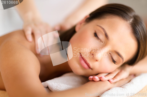 Image of beautiful woman in spa salon getting massage