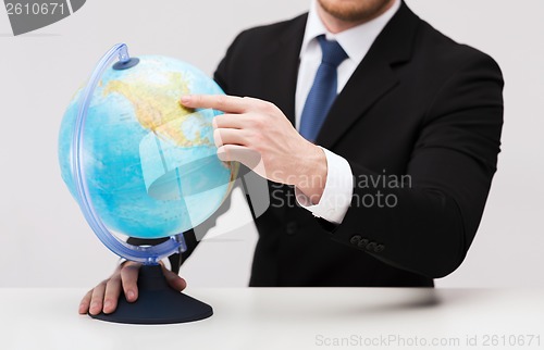 Image of businessman pointing finger to earth globe