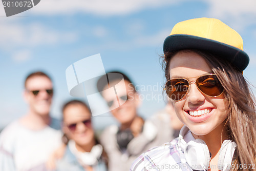 Image of teenage girl with headphones and friends outside