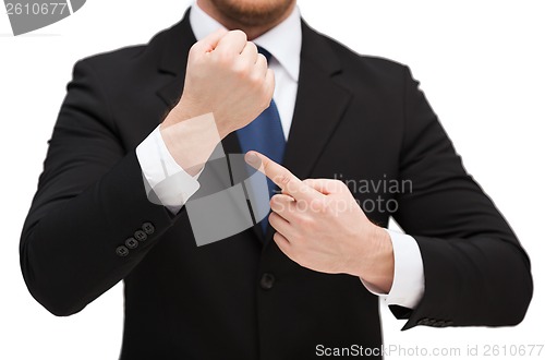 Image of businessman pointing to something at his hand