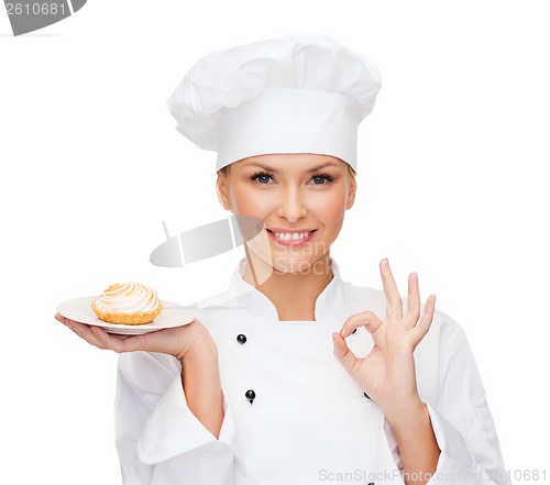 Image of smiling female chef with cake on plate