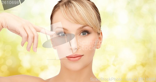 Image of beautiful woman touching her eye area