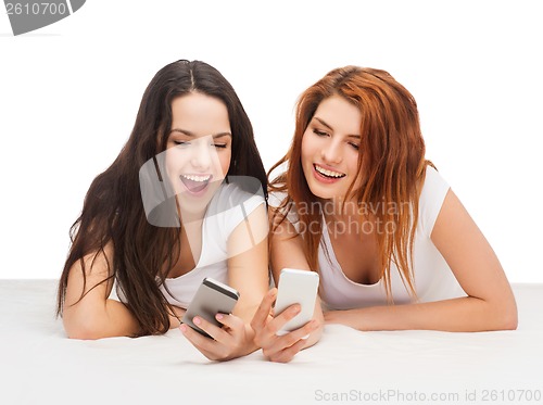 Image of two smiling teenagers with smartphones