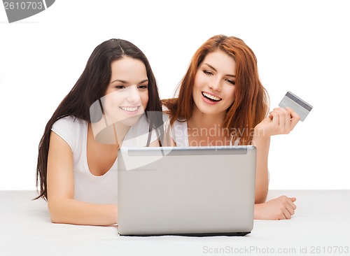 Image of two smiling teenagers with laptop and credit card