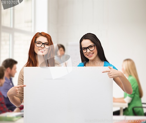 Image of two smiling girls with eyeglasses and blank board