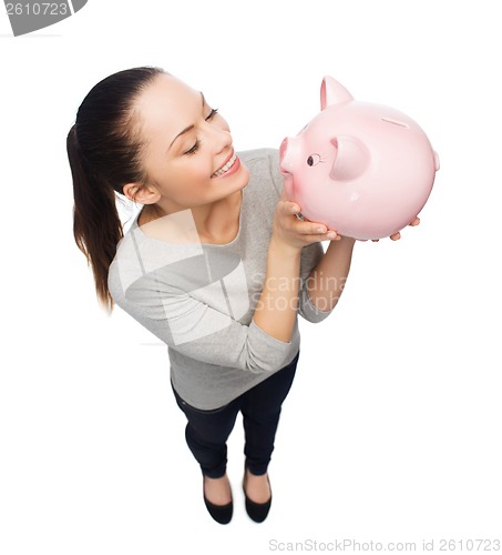 Image of happy woman looking at piggy bank