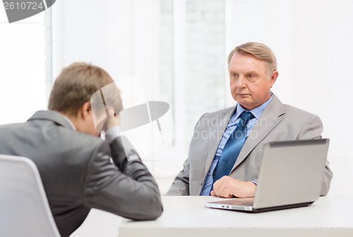 Image of older man and young man having argument in office