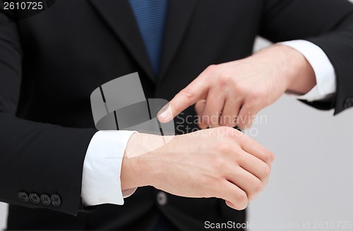 Image of businessman pointing to something at his hand