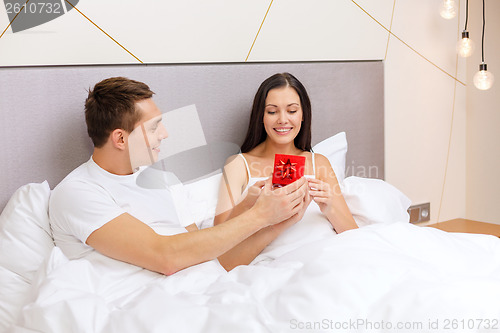 Image of man giving woman little red gift box