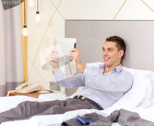 Image of happy businesswoman with tablet pc in hotel room