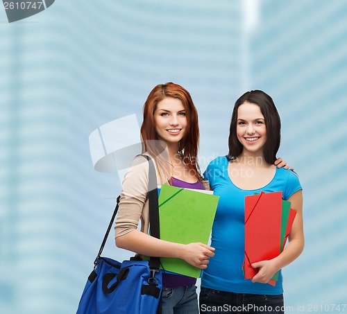 Image of two smiling students with bag and folders