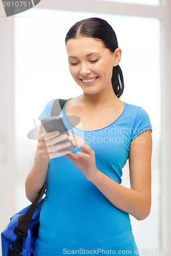 Image of smiling female student with smartphone and bag