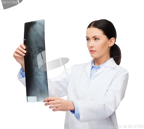 Image of serious female doctor looking at x-ray