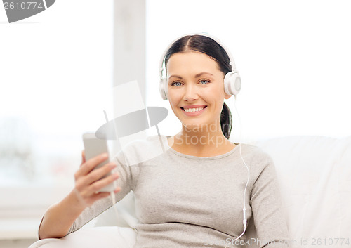 Image of woman with smartphone and headphones at home