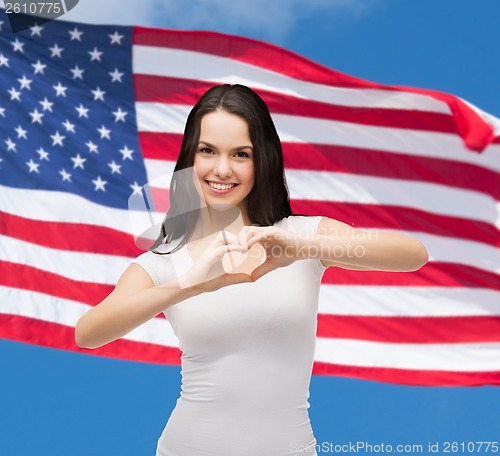 Image of smiling girl showing heart with hands