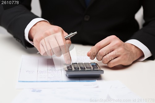 Image of close up of businessman with papers and calculator