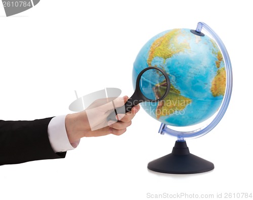 Image of businessman hand holding magnifier over globe