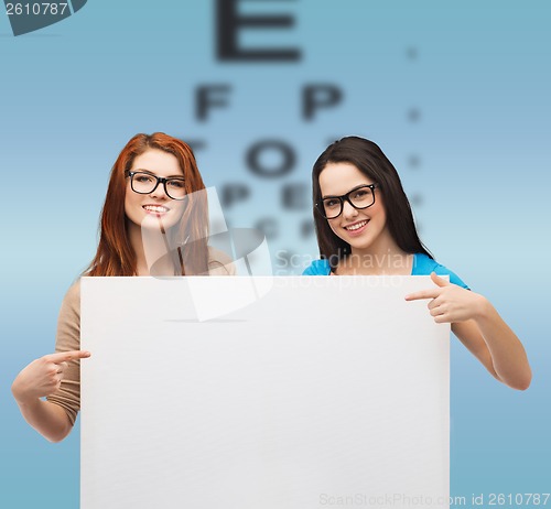 Image of two smiling girls with eyeglasses and blank board