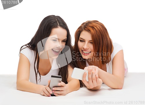 Image of two smiling teenagers with smartphones