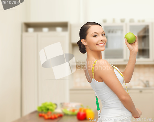 Image of sporty woman with apple and measuring tape