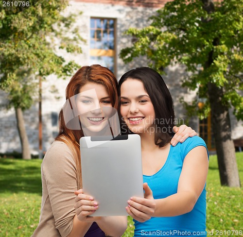 Image of two smiling teenagers with tablet pc computer