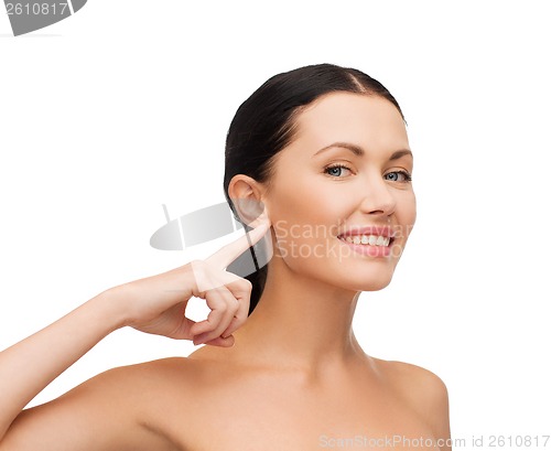 Image of young calm woman pointing to her ear