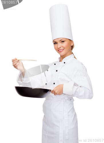 Image of smiling female chef with pan and spoon