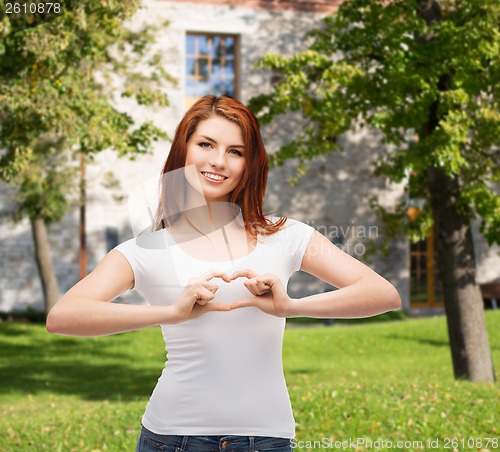 Image of smiling girl showing heart with hands