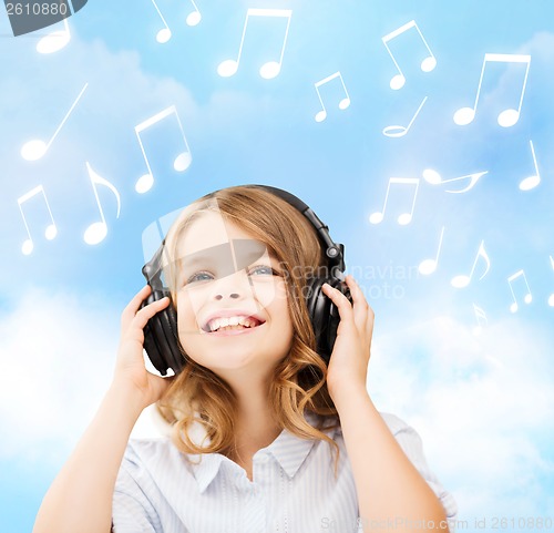 Image of smiling little girl with headphones at home