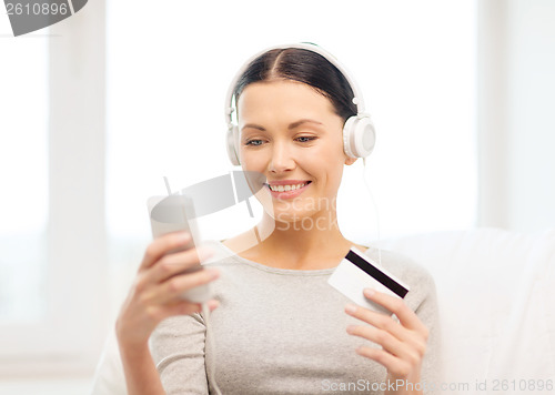 Image of woman with smartphone and headphones at home