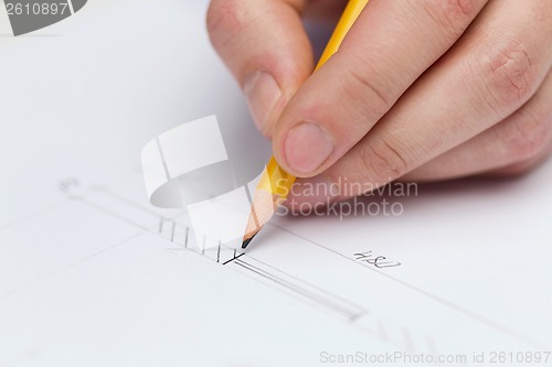 Image of male contractor making changes to blueprint