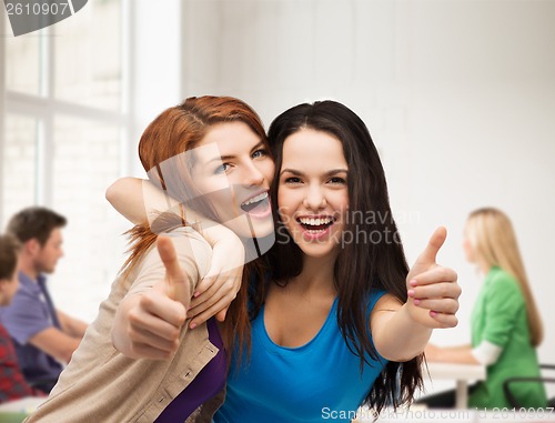 Image of two smiling girls showing thumbs up