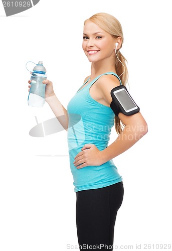 Image of sporty woman running with smartphone and earphones