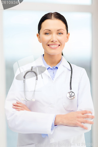 Image of smiling young doctor with stethoscope in cabinet